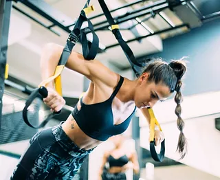 Femme s'entraînant avec TRX